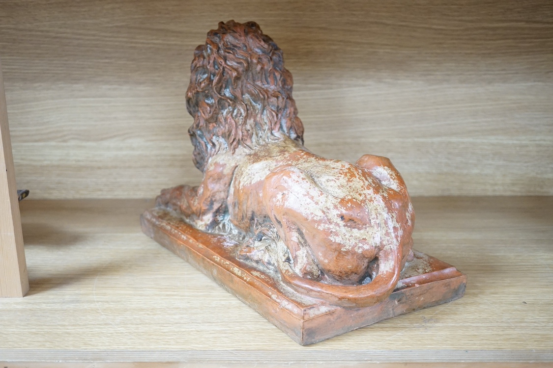 A terracotta sculpture of a lion, 39cm wide. Condition - good